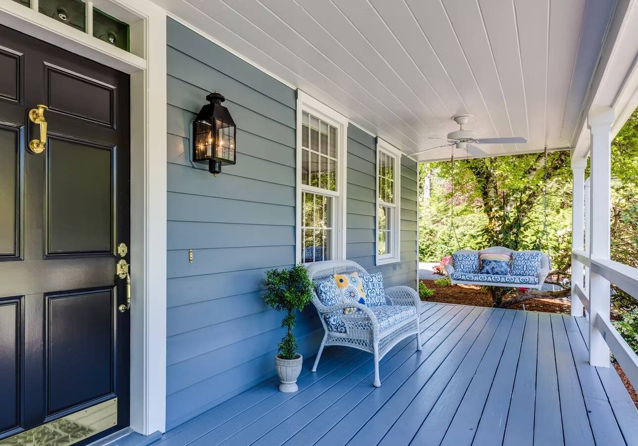 1747725676056_IMAGE-54379_20_2824_29 Charming blue porch with wicker furniture.