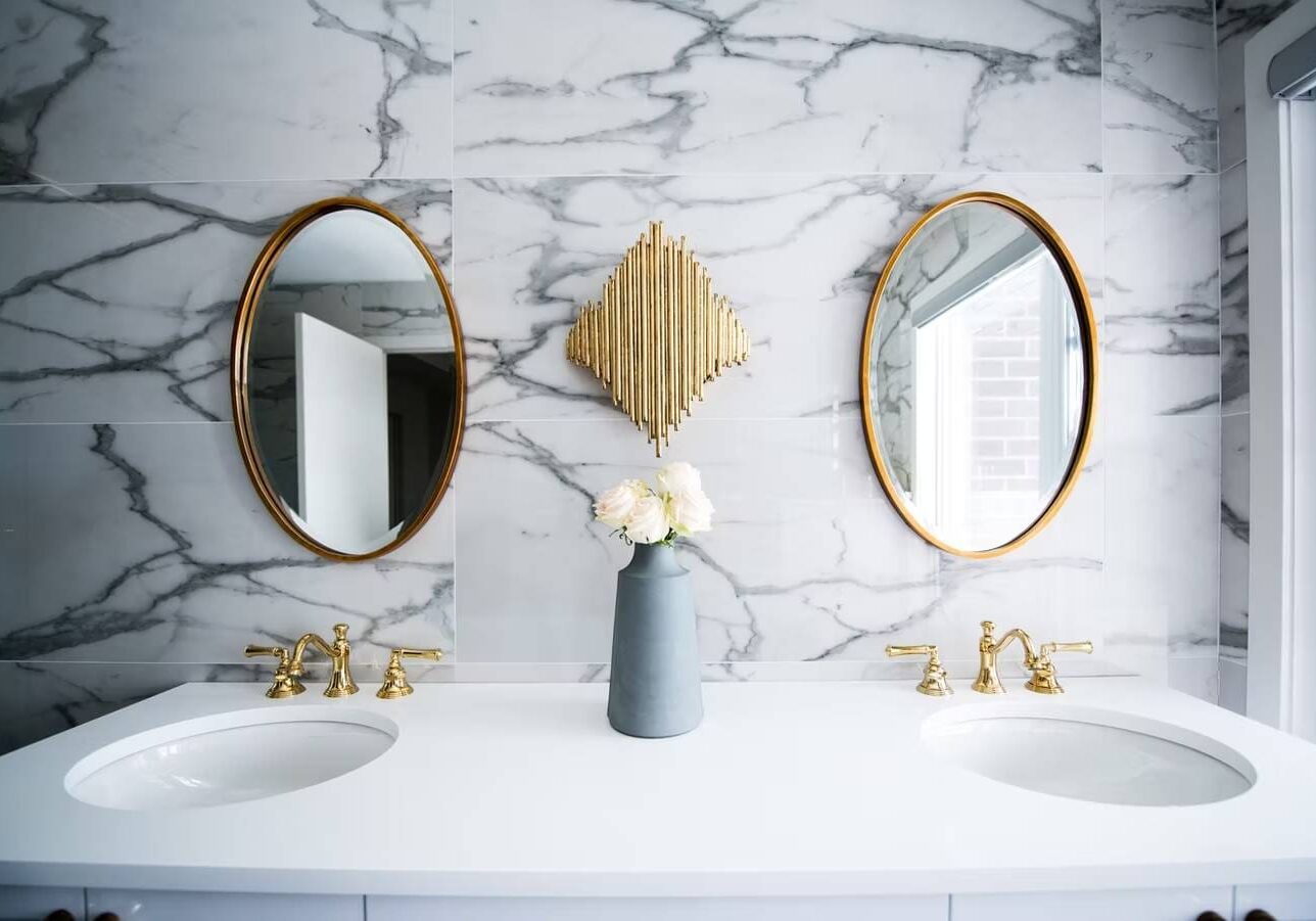 1747725746774_IMAGE-54379_20_2825_29 Elegant bathroom with gold fixtures and mirrors.
