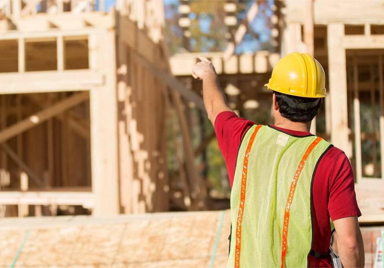 1747725746780_IMAGE-54379_20_2812_29 Construction worker pointing at building framework.
